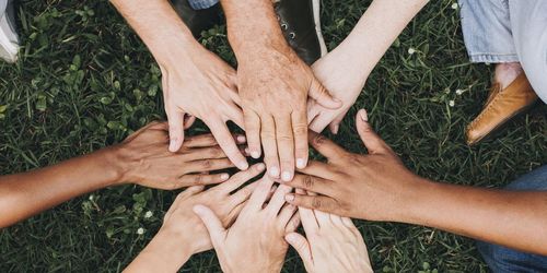 Personen legen ihre Hände in der Mitte zusammen