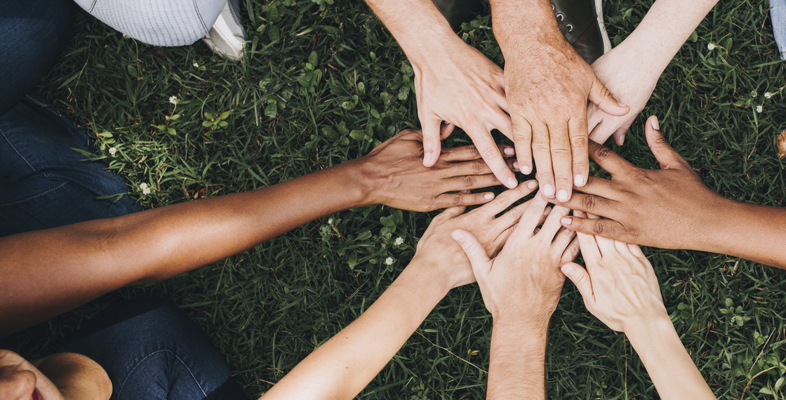 Personen legen ihre Hände in der Mitte zusammen