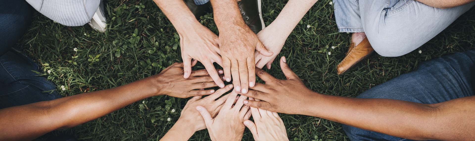 Personen legen ihre Hände in der Mitte zusammen
