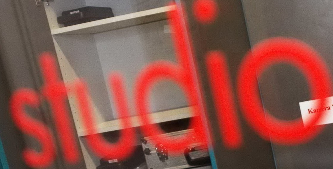 Programmförderungsantrag - Blick in Redaktion hinter Glastür mit Aufschrift "Studio"